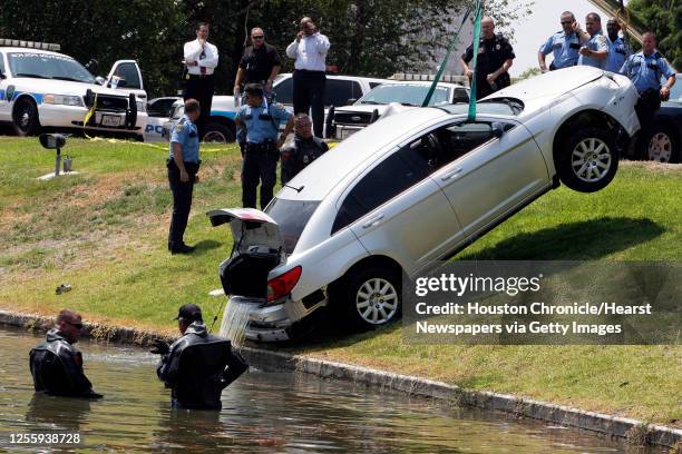 Houston Police Department dive team officers recovery an automobile involved in an earlier police incident from a pond at Hidalgo and Post Oak...