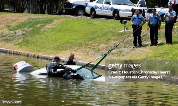 Houston Police Department dive team officers recovery an automobile involved in an earlier police incident from a pond at Hidalgo and Post Oak...