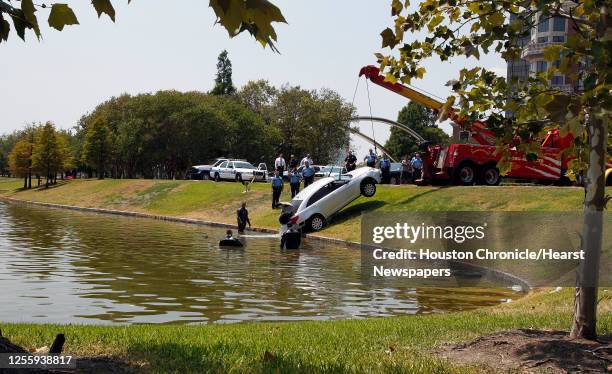 Houston Police Department dive team officers recovery an automobile involved in an earlier police incident from a pond at Hidalgo and Post Oak...