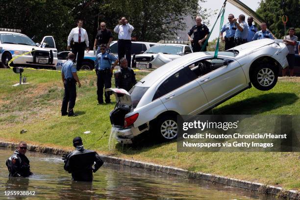 Houston Police Department dive team officers recovery an automobile involved in an earlier police incident from a pond at Hidalgo and Post Oak...