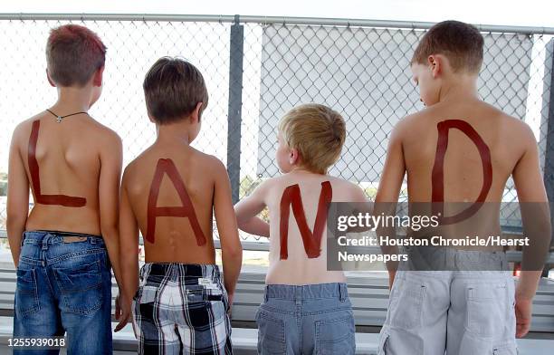 Pearland fans, from left, Charlie Clark,8., Mitchell Krum, 8., Matthew Dennis 8, and AJ Abbott .show off the word "Pear" on their chests and "Land"...