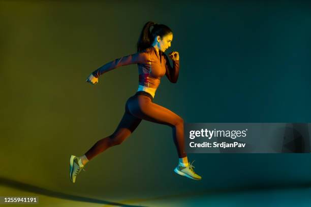 scatto in studio di una giovane sportiva che esegue il salto in corsa - sportman foto e immagini stock