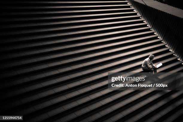 high angle view of man sitting on stairs, kyoto, japan - black and white stairs stock pictures, royalty-free photos & images