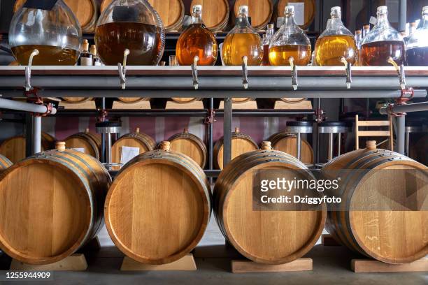 whiskey barrels in cellar - whiskey stock pictures, royalty-free photos & images
