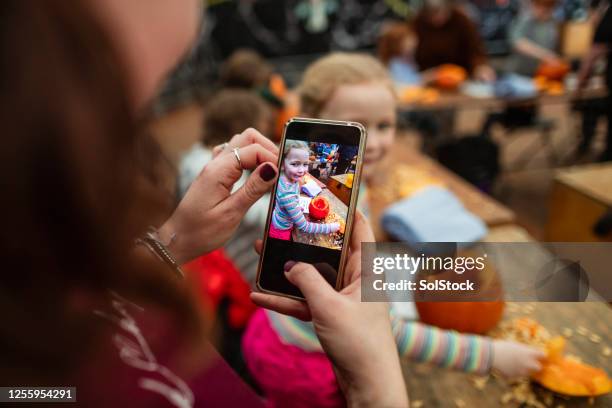 family carving pumpkins - taking photo with phone stock pictures, royalty-free photos & images