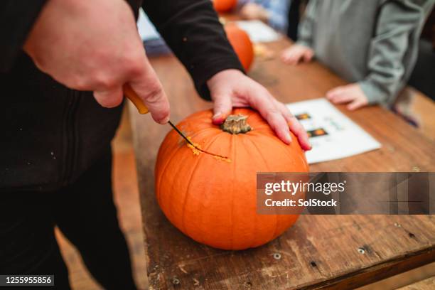 cutting into the pumpkin - schnitzen stock-fotos und bilder