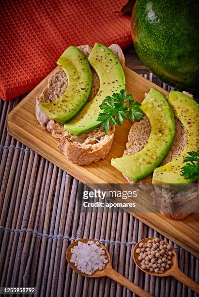 snack or appetizer of avocado slices bruschetta with olive oil, peppermint and salt - aguacates stock pictures, royalty-free photos & images