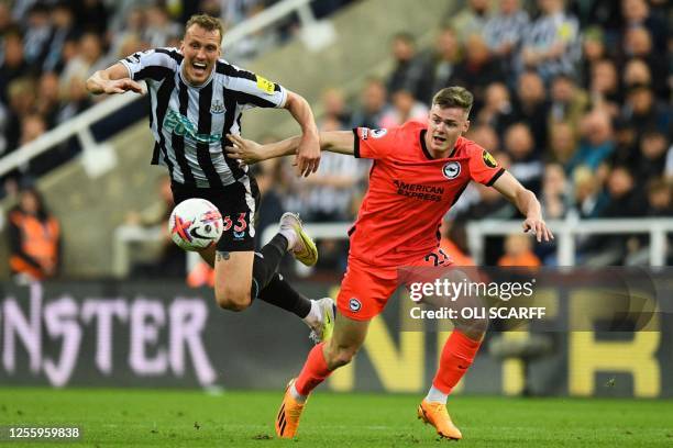 Newcastle United's English defender Dan Burn fights for the ball with Brighton's Irish striker Evan Ferguson during the English Premier League...