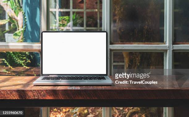 laptop computer blank white screen on table in cafe background. laptop with blank screen on table of coffee shop blur background. - monitor foto e immagini stock