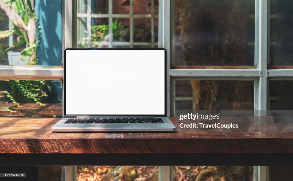 Laptop computer blank white screen on table in cafe background. Laptop with blank screen on table of coffee shop blur background.