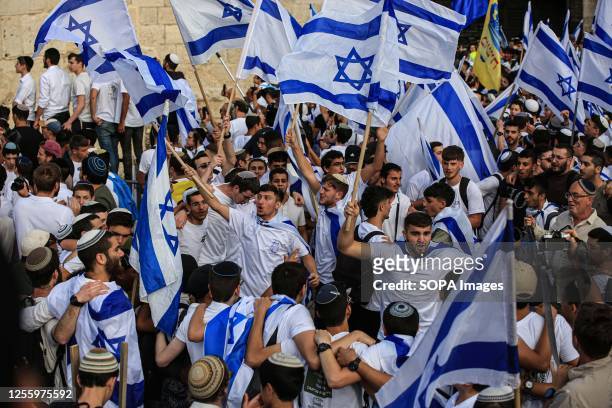 Demonstrators waving Israeli flags gather outside the Damascus Gate of the Old City of Jerusalem during the annual 'flag march' to mark 'Jerusalem...