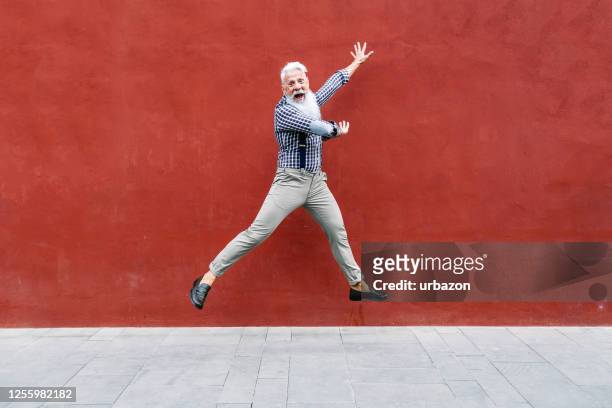 handsome senior man jump of joy - hipster senior man stock pictures, royalty-free photos & images