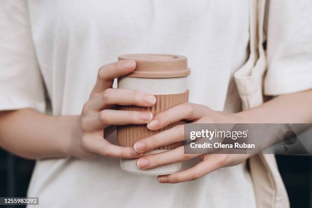 female hands hold reusable coffee mug - kaffeebecher stock-fotos und bilder