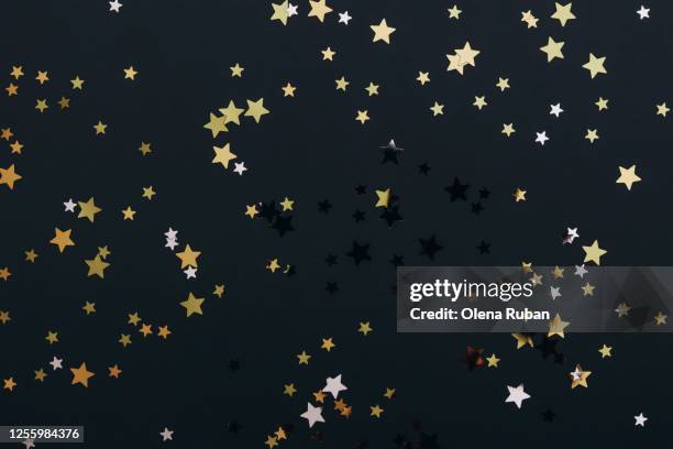 bright golden stars on black background - star background stock-fotos und bilder