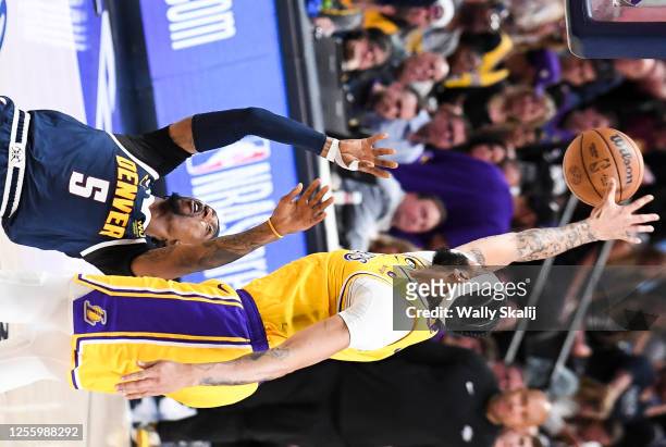 Los Angeles Lakers forward Anthony Davis, right, blocks a shot by Denver Nuggets guard Kentavious Caldwell-Pope during the first half of game two in...