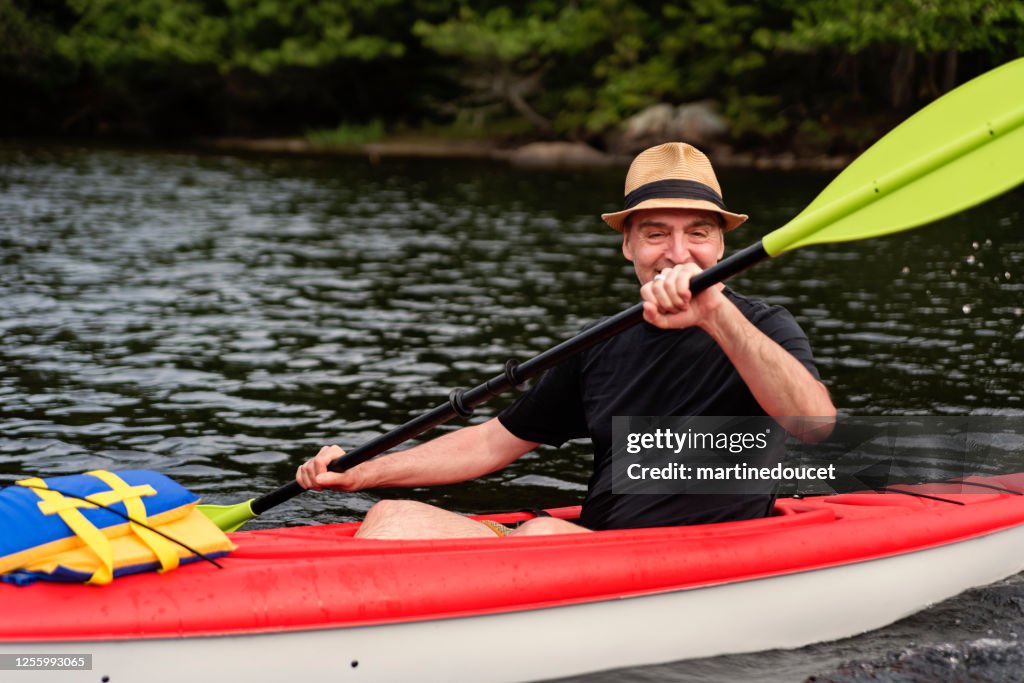 50 + man kayaking on a lake.