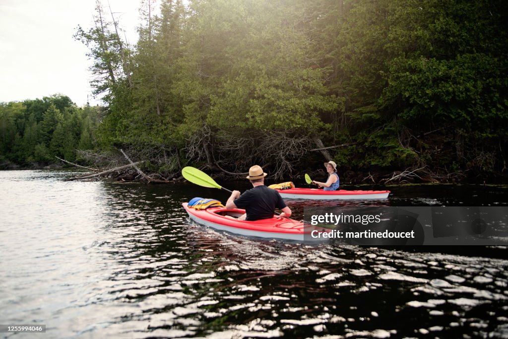 50 + man and woman kayaking on a lake.