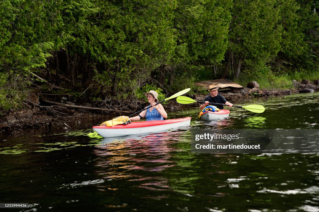 50 + man and woman kayaking on a lake.