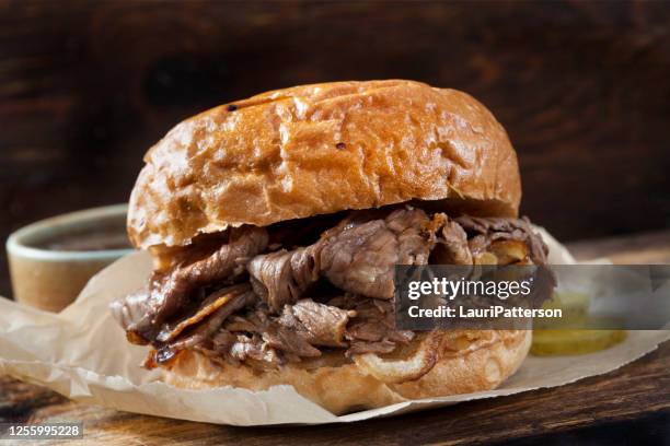 roast beef and cheddar sandwich with au jus on a toasted onion bun - roast beef sandwich stock pictures, royalty-free photos & images