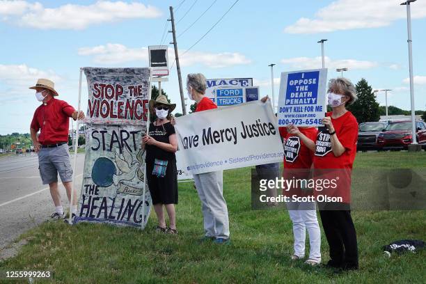 Demonstrators express opposition to the death penalty during a protest near the Federal Correctional Complex where Daniel Lewis Lee is scheduled to...