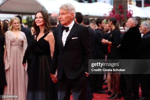 Calista Flockhart and Harrison Ford attend the "Indiana Jones And The Dial Of Destiny" red carpet during the 76th annual Cannes film festival at...