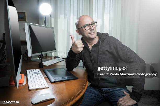 portrait of bald man working at his computer at home - hairless mouse stock pictures, royalty-free photos & images