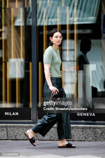 Influencer Maria Barteczko, wearing a green knit top by Zara, green wide leg leather pants by Zara, black satin mules by March & Muse, a black cotton...