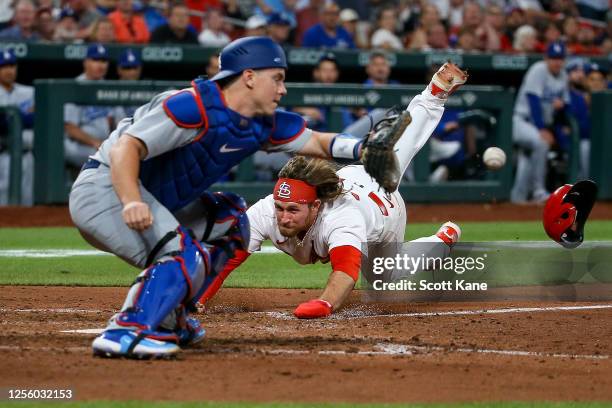 Brendan Donovan of the St. Louis Cardinals scores a run ahead of the throw to Will Smith of the Los Angeles Dodgers at Busch Stadium on May 18, 2023...