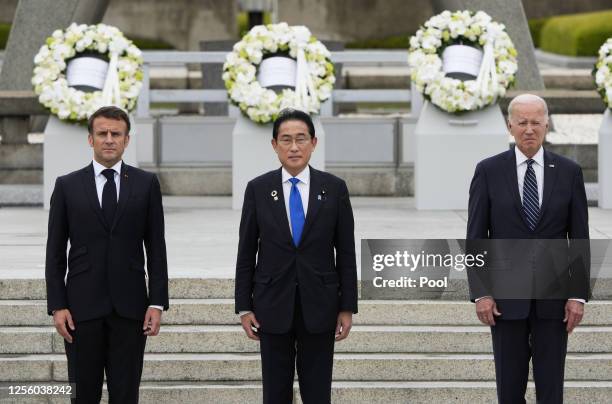 French President Emmanuel Macron, Japanese Prime Minister Fumio Kishida and U.S. President Joe Biden pose for a group photo after laying flower...
