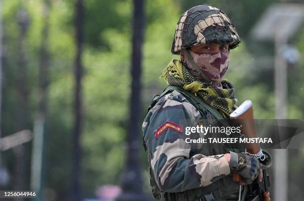 An Indian Border Security Force soldier stands guard along the shores of Dal Lake ahead of the G20 meeting in Srinagar on May 19, 2023.