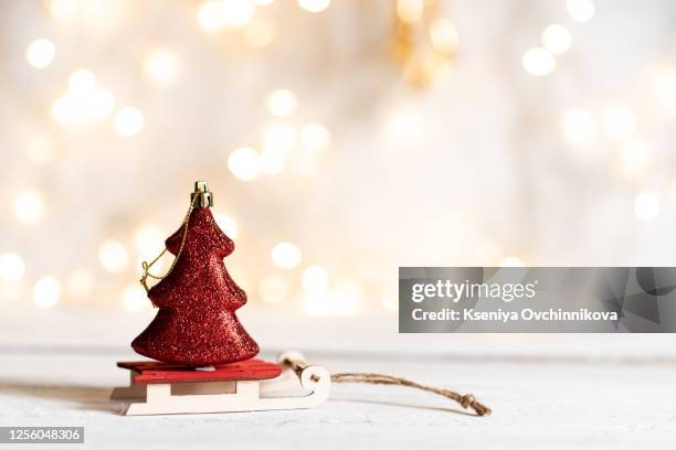 shining christmas ball on toy wooden sled on light bokeh background with goolden star. new year card. xmas decoration. - christmas toys wooden background stockfoto's en -beelden