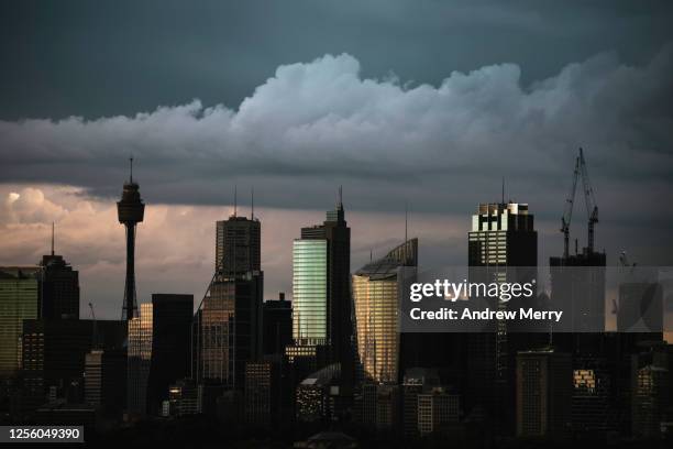 city skyline and storm clouds at dusk - financial district stock pictures, royalty-free photos & images