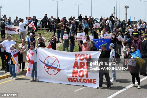 Picture taken on May 19, 2023 shows demonstrators protesting against the resumption of air links with Russia outside the Tbilisi Airport as the...