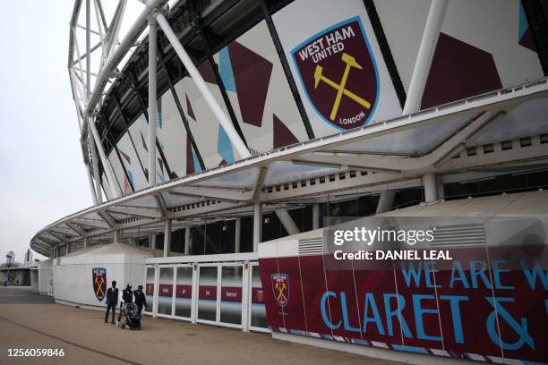 Pedestrians walk past West Ham United's London Stadium at Queen Elizabeth Olympic Park in the Stratford district of east London on May 19 a day after...