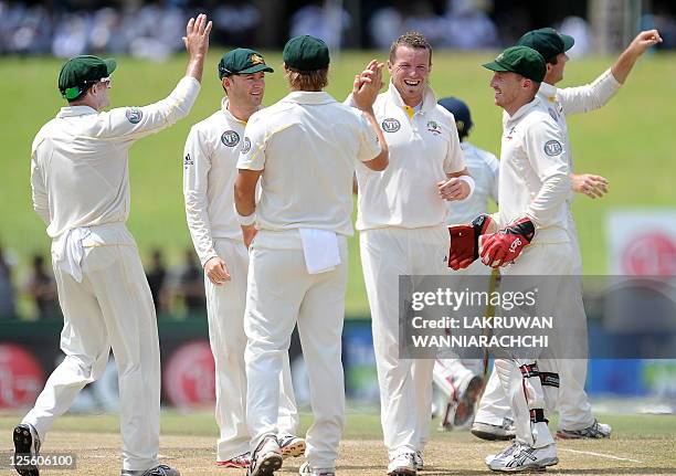 Australia bowler Peter Siddle celebrates with his teammates after he dismissed unseen Sri Lankan batsman Rangana Herath during the fourth day of the...