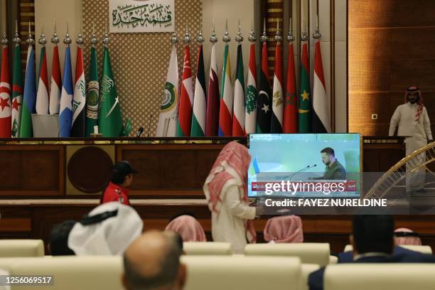Media delegates watch on a screen Ukraine's President Volodymyr Zelensky addressing the Arab League Summit in Jeddah on May 19, 2023. Zelensky...