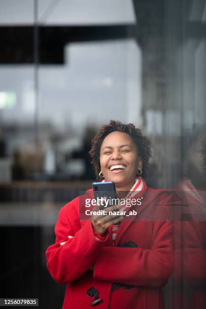 african woman smiling while using smart phone - fiji people stock pictures, royalty-free photos & images
