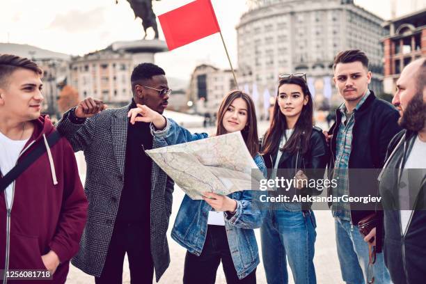 tourists sightseeing through city with map - men and women in a large group listening stock pictures, royalty-free photos & images