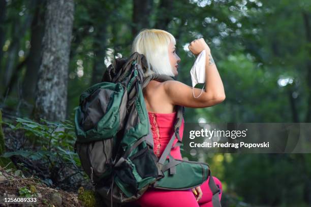 young woman enjoying in nature with mask on her hand as a sign of anti quarantine protest - anti quarantine protest - fotografias e filmes do acervo