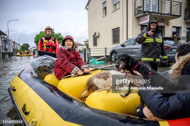 Firefighters rescuers evacuate residents in a dinghy across a flooded street after heavy rains caused flooding across Italy's northern Emilia Romagna...