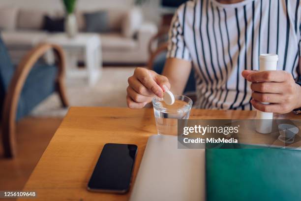 close-up shot of an unrecognizable man with a flu holding effervescent tablets - effervescent tablet stock pictures, royalty-free photos & images