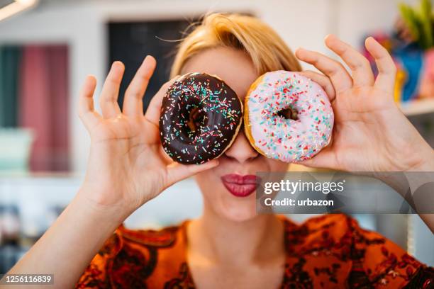woman covering her eyes with donuts - face in hole free stock pictures, royalty-free photos & images