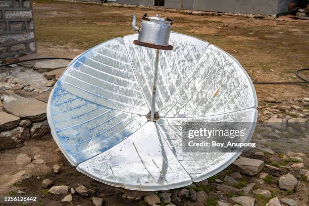 close-up of solar cooker uses the energy of the sun to cook or boiling water, reducing deforestation in remote areas of nepal. - mirror steam stockfoto's en -beelden