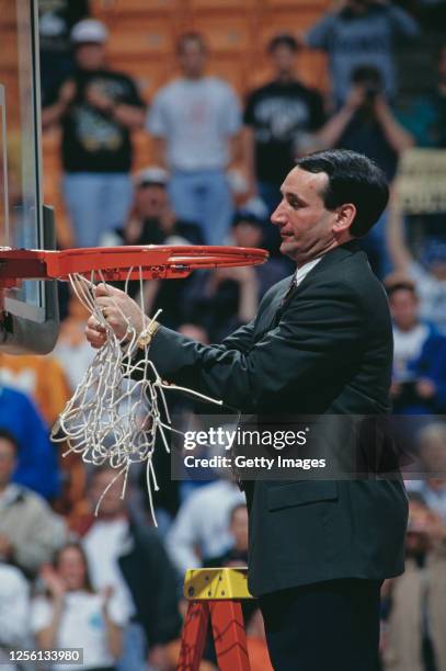 Mike Krzyzewski, Head Coach for the Duke University Blue Devils cuts the net on the backboard hoop to celebrate winning the NCAA Southeast Regional...