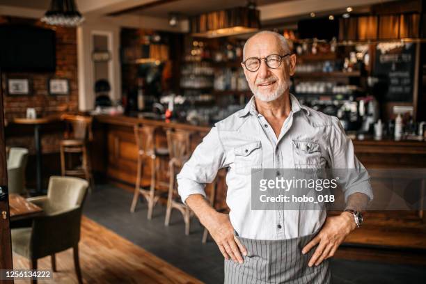 senior barista in cafe - senior men cafe stock pictures, royalty-free photos & images