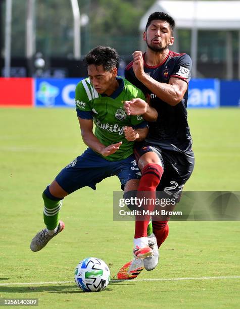 Shandon Hopeau of Seattle Sounders and Mauricio Pineda of Chicago Fire collide while fighting for the ball during a Group B match between Seattle...