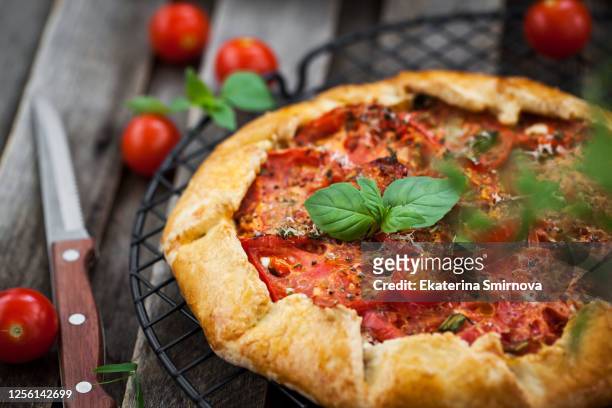 delicious homemade rustic open pie (galette) with cheese and tomato - biscotte stock-fotos und bilder