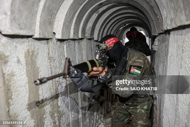 Fighters from the Democratic Front for the Liberation of Palestine walk in a tunnel in the southern Gaza Strip, on May 19, 2023.