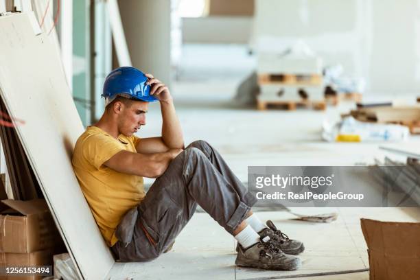 tired young man blue collar construction worker - frustrated workman stock pictures, royalty-free photos & images