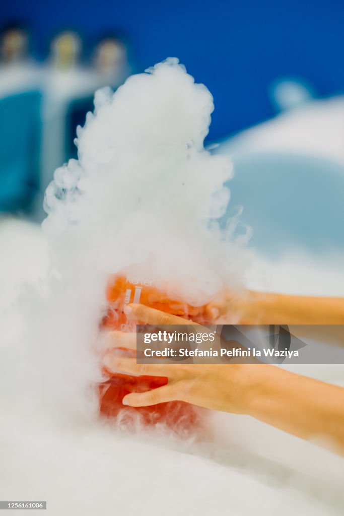 Child's hands holding bottle with edible smokey liquid nitrogen